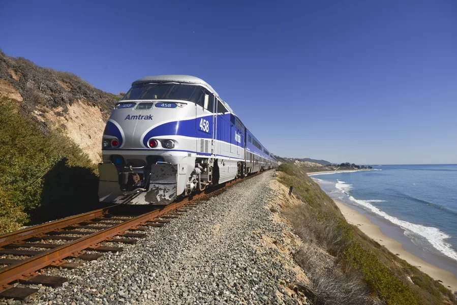 Amtrak Coast Starlight train running along the Pacific coastline in California