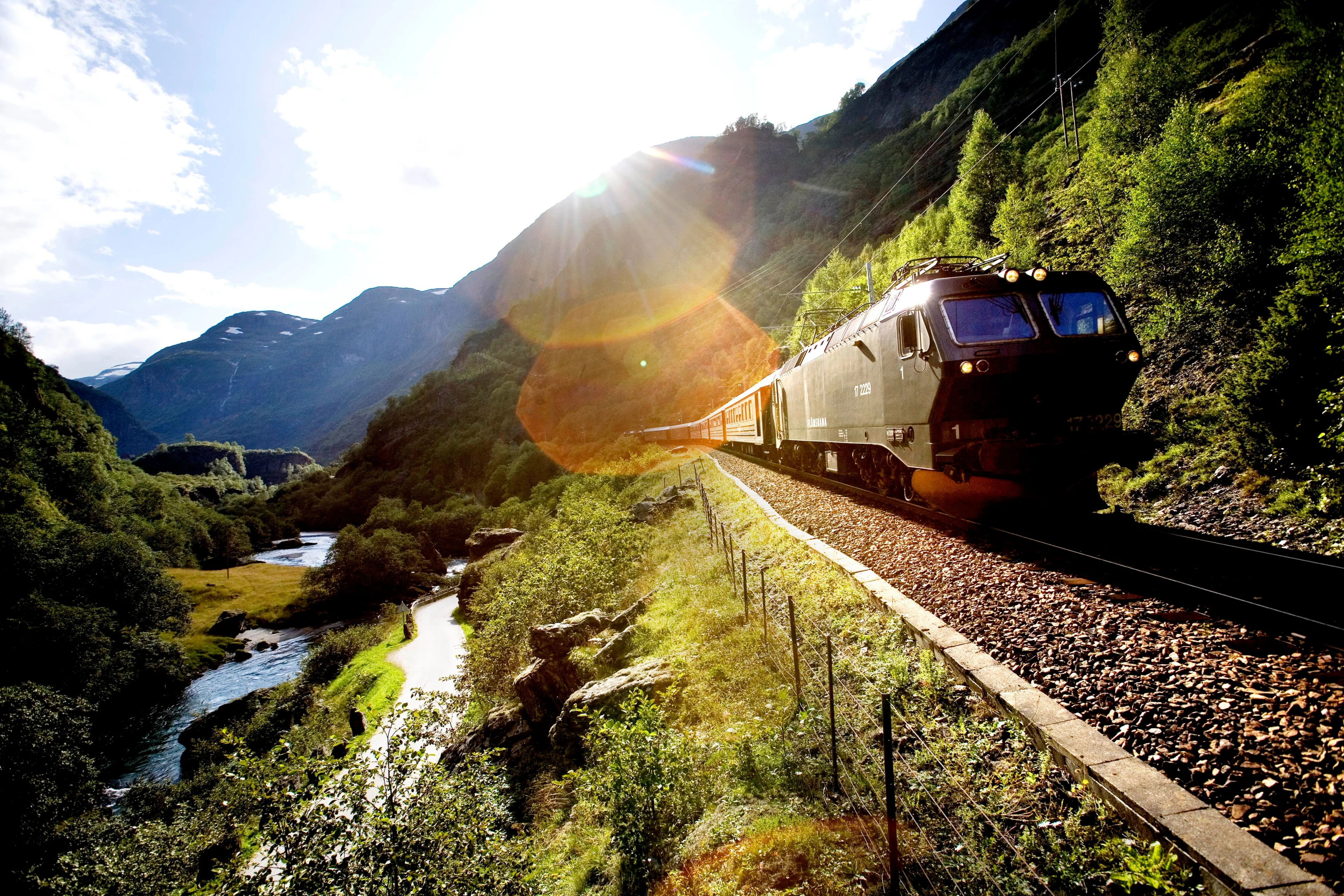 Flam Railway train descending through dramatic Norwegian fjord landscape