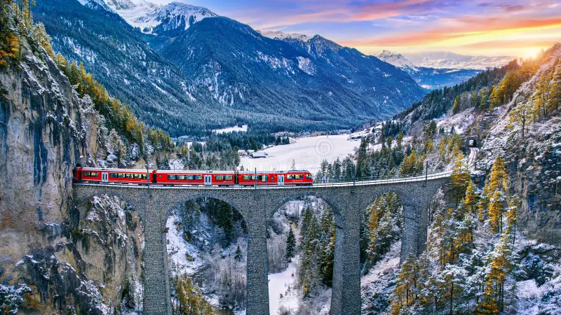 Glacier Express red train crossing the Landwasser Viaduct in the Swiss Alps